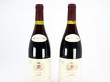 deux bouteilles de vin rouge posées l'une à côté de l'autre sur une surface blanche