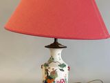 une lampe surmontée d'un abat-jour rose