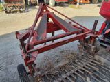 un tracteur rouge avec une charrue fixée à l'arrière