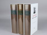 three books sitting on top of each other on a white surface