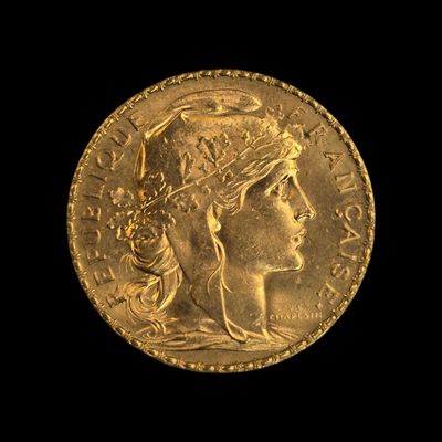 Gros plan sur une pièce d'or ornée d'une tête de femme
