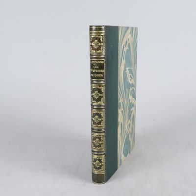 un vieux livre posé sur une table blanche à côté d'un mur blanc