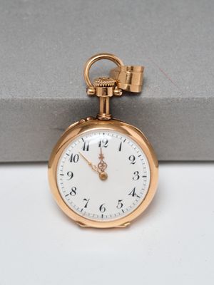 a gold pocket watch with a chain hanging from it ' s side