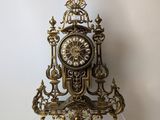 a gold clock sitting on top of a clear shelf
