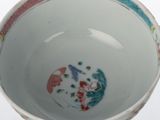 a white bowl with colorful designs on it on a white surface