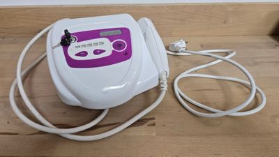 une machine blanche et violette posée sur un plancher en bois