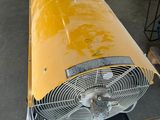 a fan that is sitting on a cart in a garage