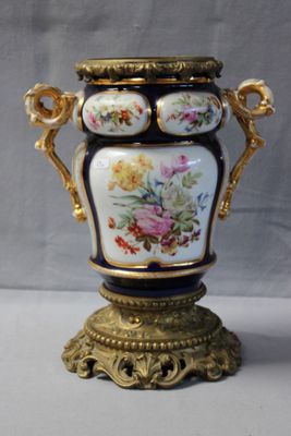 a vase that is sitting on a stand on a table