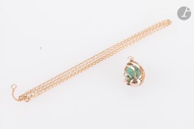 un gros plan d'un collier en or orné d'une pierre verte