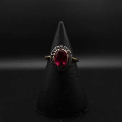Gros plan sur une bague contenant une pierre rouge