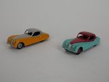 deux voitures jouets assises l'une à côté de l'autre sur une surface blanche