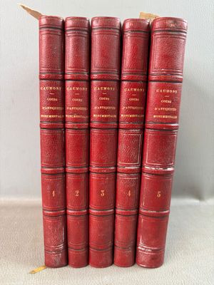 a set of five red books sitting on top of a white surface