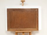 a wooden easel with a painting on it and a cross above it