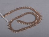 un collier de perles dorées sur un fond blanc
