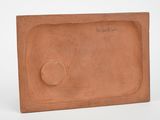 a close up of a red brick with a button on it