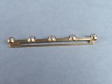 a picture of a gold tie bar with four diamonds on it