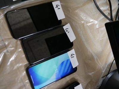 several cell phones are sitting on a table next to a laptop