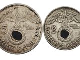 deux pièces d'argent ornées de têtes d'aigle, dont l'une présente un trou au milieu