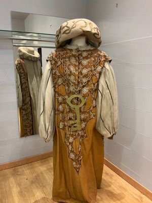 un mannequin dans un coin d'une pièce, avec des vêtements exposés