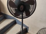 un ventilateur posé par terre à côté de l'escalier