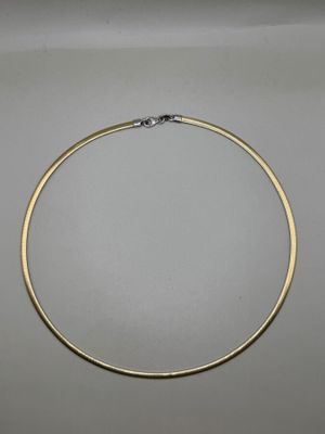 un collier fin en or orné d'un fermoir en diamant sur fond blanc