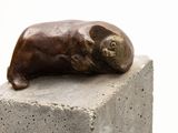 a statue of a cat laying on top of a block