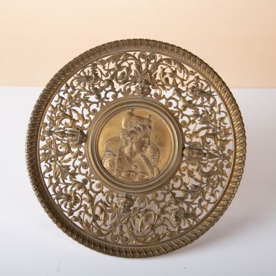 brass plate with a picture of a woman on it on a white surface