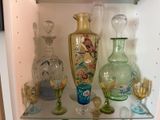 de nombreux vases et verres en verre sur une étagère