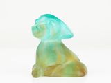 a glass figurine of a cat sitting on a white surface