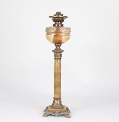 an antique brass table lamp with a glass shade on top