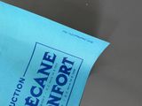 a blue bag with a sign on it sitting on a table
