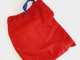a red bag with a blue handle sitting on a white surface