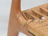 a close up of a wooden chair with a woven seat