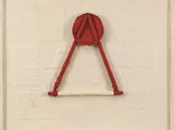 une photo d'un objet rouge sur un mur blanc