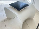 a white bench with a blue pillow on it