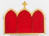 a close up of a red and gold crown with a cross on top