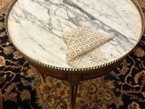 une table basse au plateau en marbre posée sur un tapis dans un salon