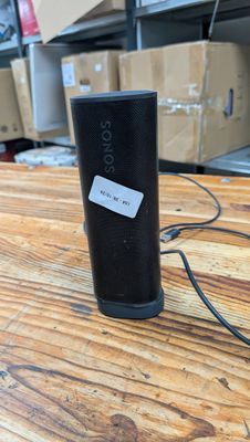 une image représentant une enceinte noire posée sur une table en bois
