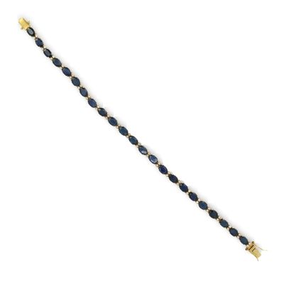 un bracelet en or orné de perles de verre bleues sur fond blanc