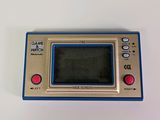 an old game console with a blue screen sitting on top of a white table