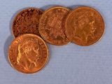 four different types of gold coins on a blue surface