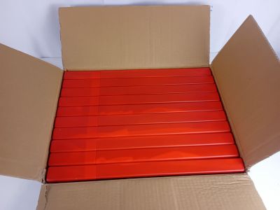 une boîte en carton contenant des bandes rouges, posée sur une surface blanche