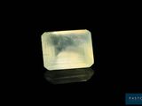 a close up of a yellow diamond on a black surface