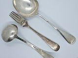 three silver spoons and two silver spoons on a white table
