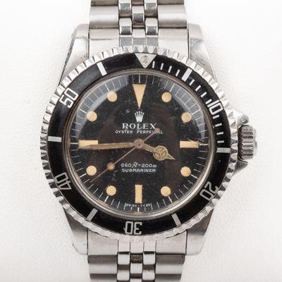 an image of a rolex watch with a black dial and gold hands