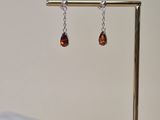 a close up of a pair of earrings on a stand on a table