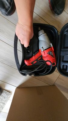 a person holding a tool in a case on the floor