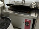 a small stove with a pan on it in a kitchen