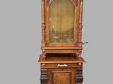 an old wooden cabinet with a glass door on top of it