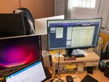 un bureau sur lequel sont posés deux écrans et un ordinateur portable